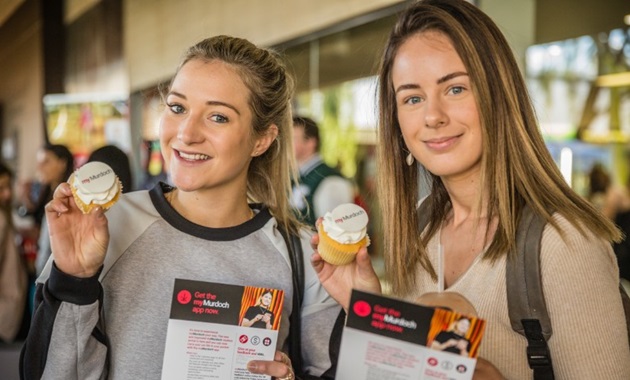 two girls holding student portal cupcakes