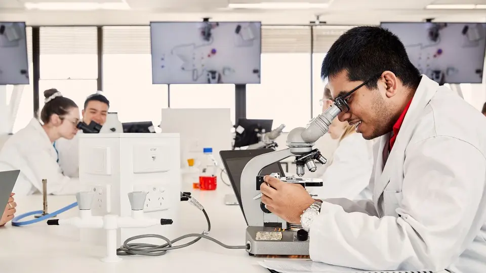 Murdoch University research students looking through microscope equipment