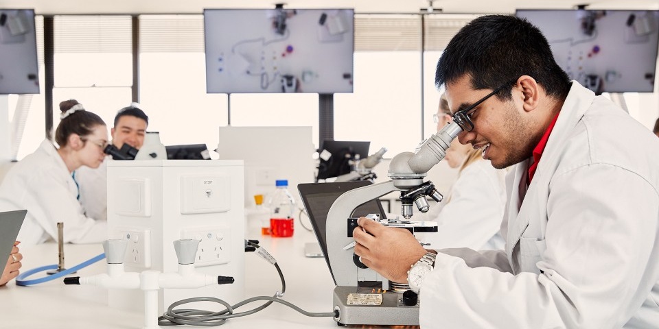 Murdoch University research students looking through microscope equipment