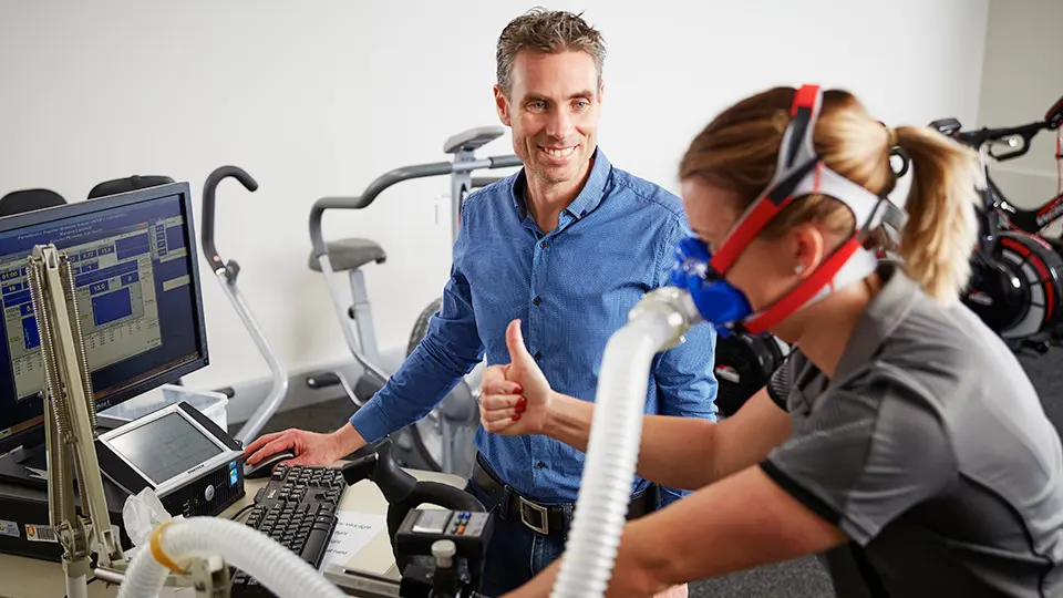 Person on exercise bike with measurement equipment attached