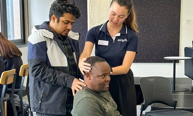 Woman demonstrating to another man manipulation techniques on a subjects head