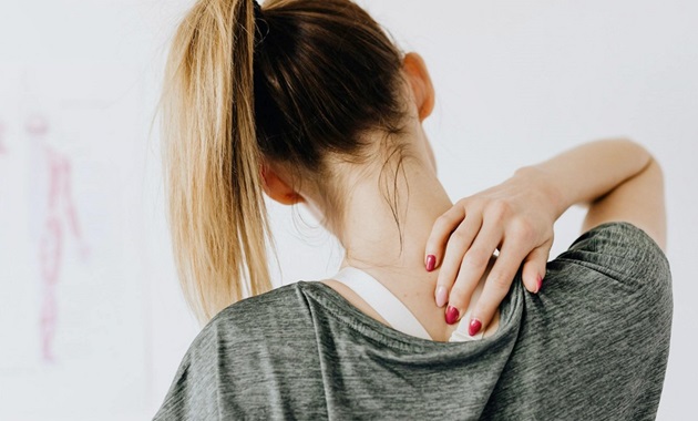 Woman holding back neck in pain