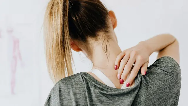 Woman holding back neck in pain