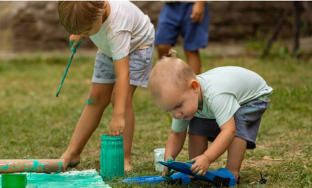 Childre playing with paint outside
