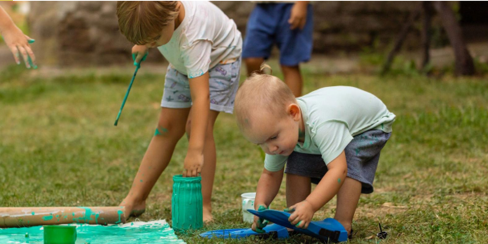 Childre playing with paint outside