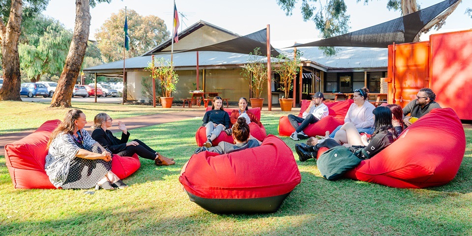 Group of people sitting on bean bags outside