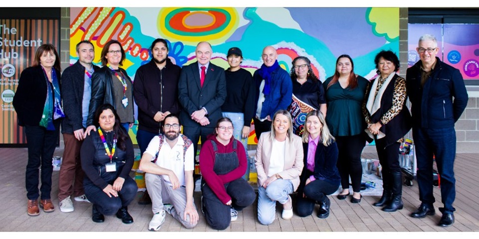 Aboriginal and Torres Strait Islander staff, students and allies infront of bush court mural