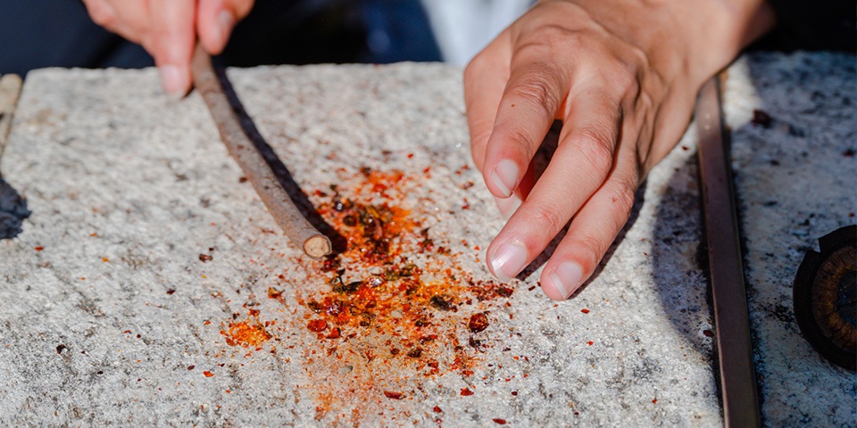 Stick crushing bright coloured powder on stone