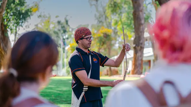 Indigenous man presenting to group in exterior setting