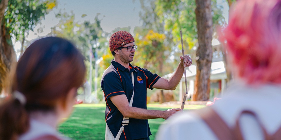 Indigenous man presenting to group in exterior setting