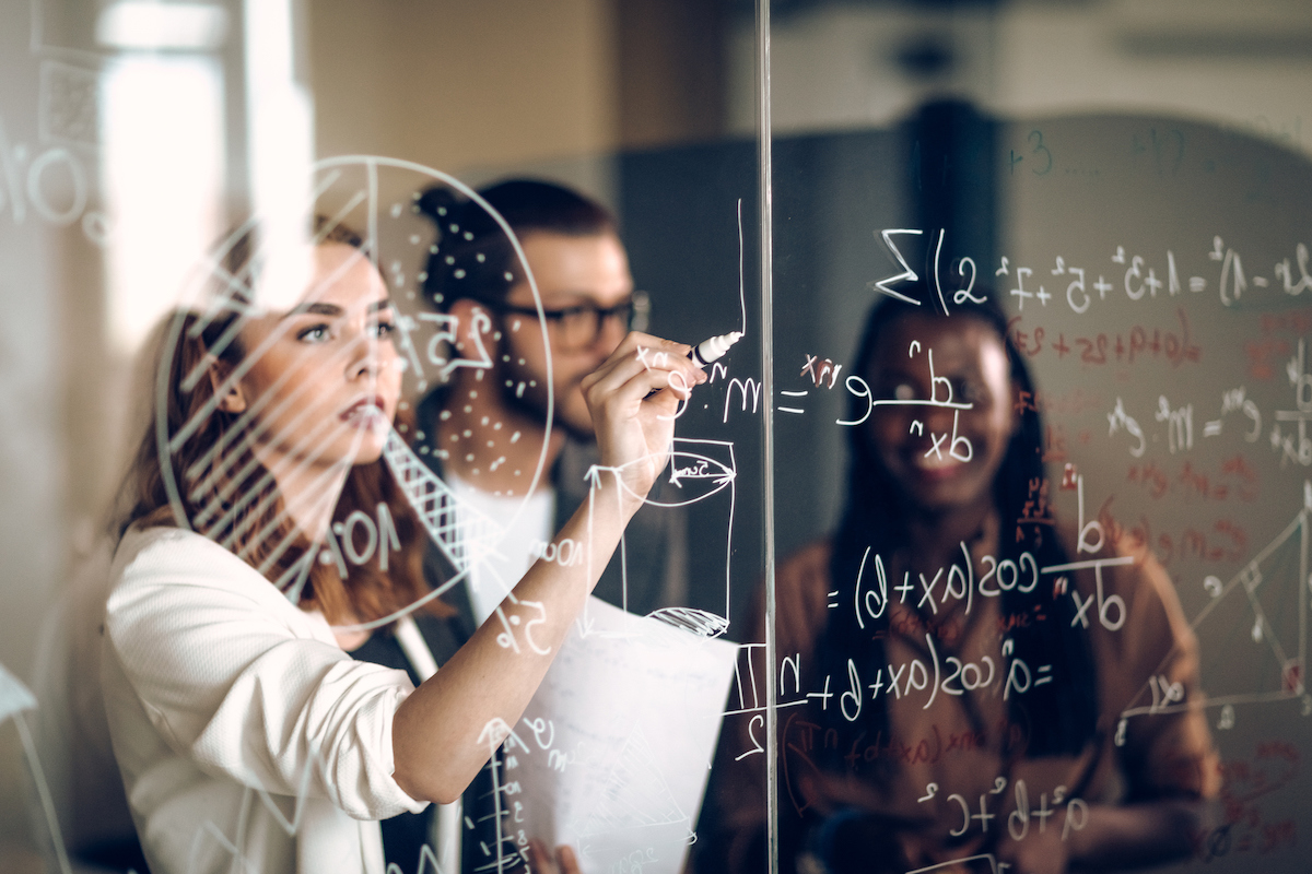 girl writing on glass board