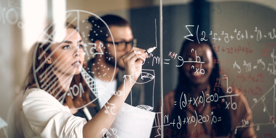 girl writing on glass board