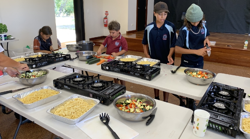 Indigenous children preparing food in kitchen