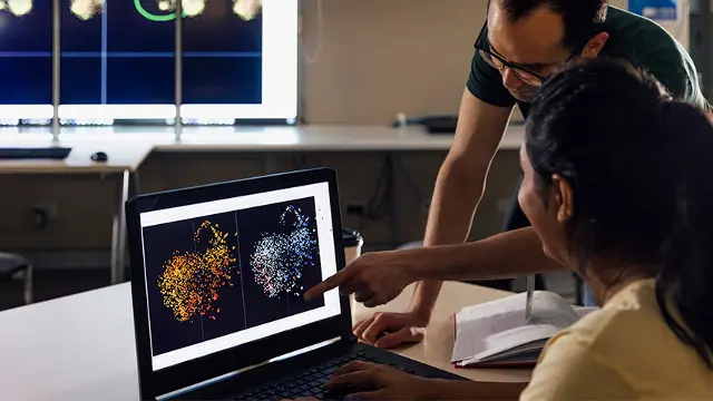 2 people looking at a screen with results