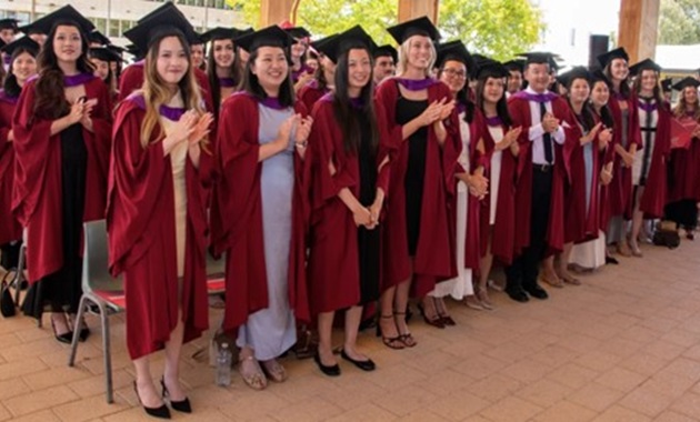 Group of students graduating wearing red gowns