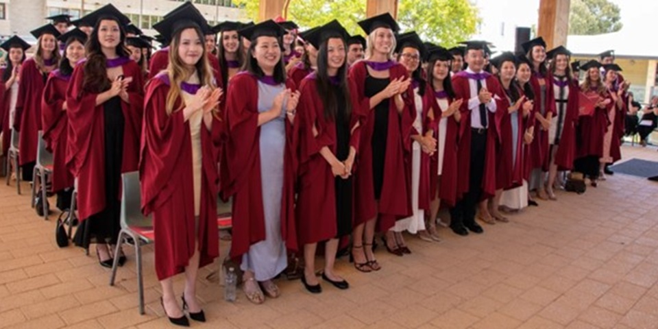 Group of students graduating wearing red gowns