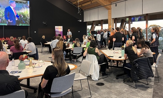 Group of people watching a presentation on large screen