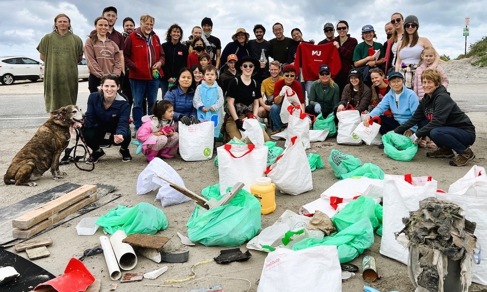 plastic free july beach cleanup group of students on beach cleanup