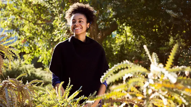 Young person standing amongst banksias